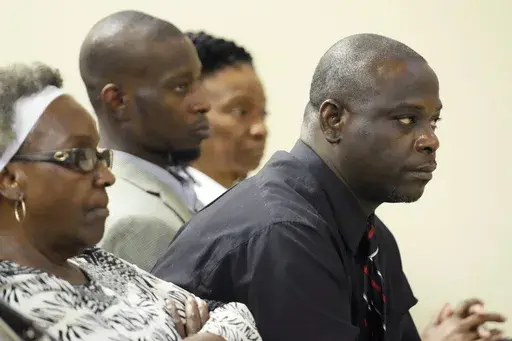 Eddie Terrell Parker, right, and Michael Corey Jenkins, center, listen as one of six former Mississippi law officers pleads guilty to state charges at the Rankin County Circuit Court in Brandon, Miss., Monday, Aug. 14, 2023. Information unveiled in a justice department investigation and media reports show that a Mississippi sheriff who leads a department where former deputies tortured the two Black men in a racially motivated assault failed to train his deputies properly, the men's attorneys say