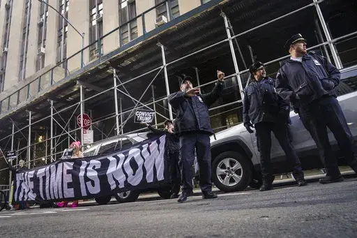 Demonstrators unveil a banner outside Manhattan's district attorney office, supporting a grand jury vote to indict former President Donald Trump, Thursday March 30, 2023, in New York. A Manhattan grand jury has voted to indict Donald Trump on charges involving payments made during the 2016 presidential campaign to silence claims of an extramarital sexual encounter, his lawyers said Thursday, producing the first criminal case against a former U.S. president and a jolt to Trump’s bid to retake t