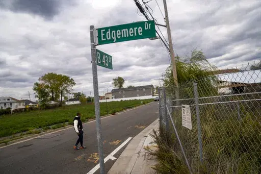 Dexter Davis, a neighborhood resident, walks the street between two abandoned residential lots 10 years after the area was severely damaged by Superstorm Sandy, Wednesday, Oct. 19, 2022, in the Edgemere neighborhood of the Queens borough of New York. There are no skateparks in Edgemere. No coffee shops. In fact, said Davis, a former NYC police officer, laments that there are few places for young people to go. "The things that they pump into the other communities around us are more positive (AP P