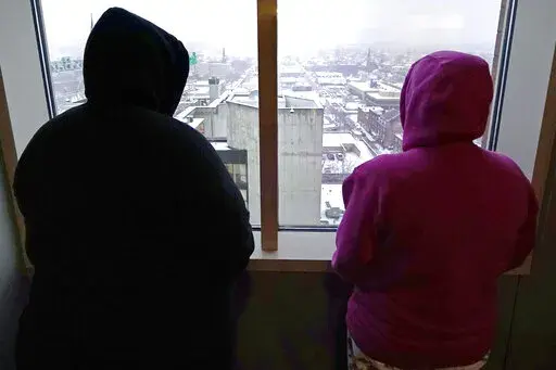 Two women, who allege abuse as minors by the ex-operations chief at New Hampshire's youth detention center, stand in their lawyer's office Thursday, Jan. 12, 2023, in Manchester, N.H. Twenty men and women say they were physically or sexually assaulted as children at New Hampshire's youth detention center by a man who went on to become the facility's chief of operations and later served on a committee advising the state on juvenile justice issues. (AP Photo/Charles Krupa)