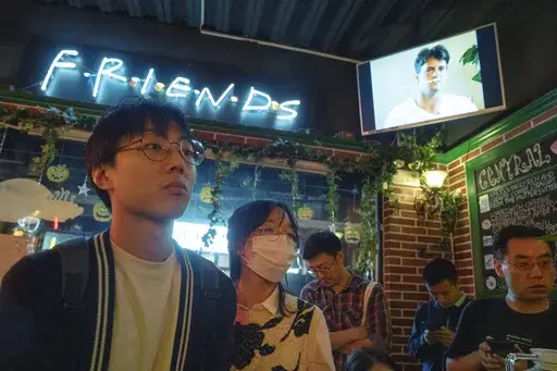 Fans of the hit sit-com "Friends" gather at a cafe that pays homage to the Central Perk cafe in the series to commemorate the death of Matthew Perry who played the Chandler Bing character, in Shanghai, Wednesday, Nov. 1, 2023. Long before "Friends" made its official debut in China, the show was a word-of-mouth phenomenon in the country. In the wake of Matthew Perry's death at 54, fans in China are mourning the loss of the star who felt less like a distant celebrity and more like an old friend. (