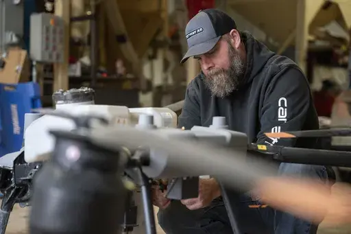 Russell Hedrick prepares a DJI drone to put crop cover on his farm, Tuesday, Dec. 17, 2024, in Hickory, N.C. (AP Photo/Allison Joyce)