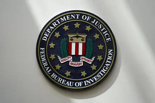 An FBI seal is seen on a wall on Aug. 10, 2022, in Omaha, Neb. The FBI sounded the alarm Monday, Dec. 19, about an explosive increase in teenage boys being targeted online and extorted for money after being tricked into sending sexually explicit pictures. (AP Photo/Charlie Neibergall, File)