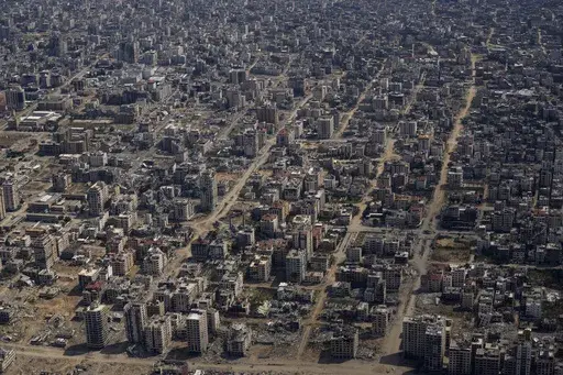 Destroyed buildings are seen through the window of an airplane from the U.S. Air Force overflying the Gaza Strip, on March 14, 2024. (AP Photo/Leo Correa, File)