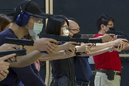People shoot air soft guns at a private civilian training organization named Polar Light Training in New Taipei City, Taiwan on June 21, 2022. While an invasion doesn’t appear imminent, China's recent large-scale military exercises in response to a visit by U.S. House Speaker Nancy Pelosi to Taiwan have made the government in Taipei more aware than ever of the hard power behind Beijing’s rhetoric about bringing the self-ruled island under its control. Experts said that civilian defense and r
