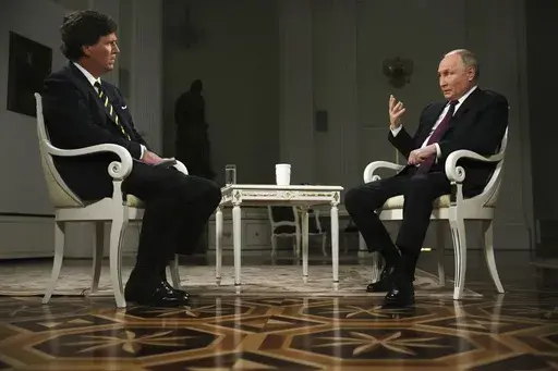 In this photo released by Sputnik news agency on Friday, Feb. 9, 2024, Russian President Vladimir Putin, right, gestures as he speaks during an interview with former Fox News host Tucker Carlson at the Kremlin in Moscow, Russia, Tuesday, Feb. 6, 2024. (Gavriil Grigorov, Sputnik, Kremlin Pool Photo via AP)