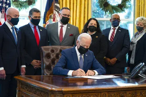 President Joe Biden signs an executive order to improve government services, in the Oval Office of the White House, Monday, Dec. 13, 2021, in Washington. (AP Photo/Evan Vucci)