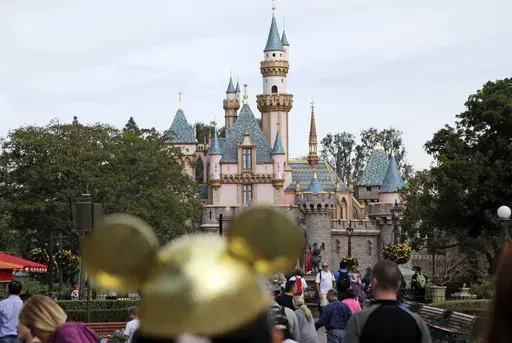 In this Jan. 22, 2015 file photo, visitors walk toward the Sleeping Beauty's Castle in the background at Disneyland Resprt in Anaheim, Calif. Last year, 2022, marked a return to normal for the theme park industry around the world with operators reporting revenues, and sometimes attendance, at par or above pre-pandemic levels, according to a new report. (AP Photo/Jae C. Hong, File)