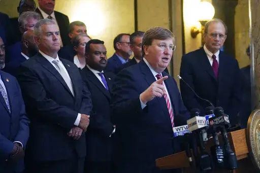 Gov. Tate Reeves, center, speaks at a news conference after lawmakers approved $247 million in state incentives for an economic development project during a special session of the Mississippi Legislature in Jackson, Miss., on Wednesday, Nov. 2, 2022. Joining the governor were a bi-partisan group of lawmakers and chamber leaders, House Speaker Philip Gunn, R-Clinton, left, and Lt. Gov. Delbert Hosemann, right. (AP Photo/Rogelio V. Solis)