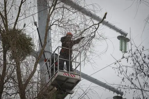 Workers of the electricity supply company DTEK maintain power lines by cutting off excess branches in Kyiv, Ukraine, Thursday, Dec. 8, 2022. Ukrainian utility crews struggling to patch up power lines during a two-month Russian military blitz targeting Ukrainian infrastructure are learning to adapt. And just as on the battlefield, Ukrainians are learning to respond quickly on the new energy front drawn inside homes, hospitals, offices, and schools in yet another act of defiance against a powerful