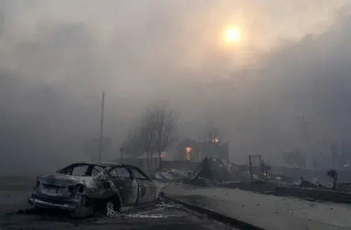 A burned-out car sits among rubble in the downtown Altadena section of Pasadena, Calif., Jan. 8, 2025. (AP Photo/Chris Pizzello, File)