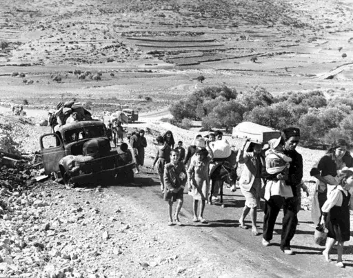 A group of Arab refugees walks along a road from Jerusalem to Lebanon, carrying their belongings with them on Nov. 9, 1948. The group was driven from their homes by attacks in Galilee. For the first time, the United Nations will officially commemorate the flight of hundreds of thousands of Palestinians from what is now Israel on the 75th anniversary of their exodus, an action stemming from the U.N.’s partition of British-ruled Palestine into separate Jewish and Arab states. (AP Photo/Jim Pring