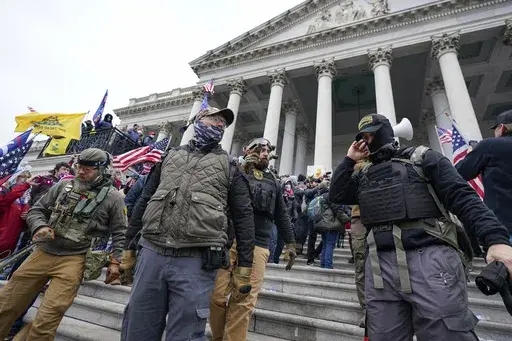 Members of the Oath Keepers extremist group stand on the East Front of the U.S. Capitol on Jan. 6, 2021, in Washington. David Moerschel, a 45,-year-old neurophysiologist from Punta Gorda, Fla., and Joseph Hackett, a 52-year-old chiropractor from Sarasota, Fla., who stormed the U.S. Capitol with other members of the far-right Oath Keepers group, were sentenced Friday to three years in prison for seditious conspiracy and other charges, the latest in a historic string of sentences in the Jan. 6. 20