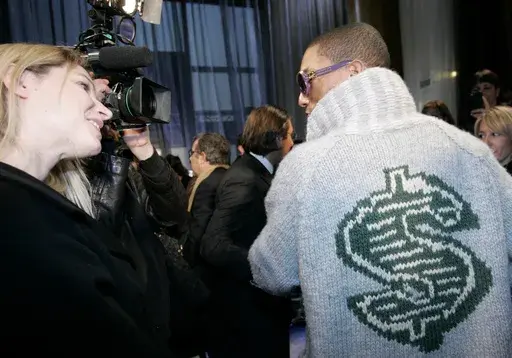 U.S rap artist Pharrell Williams, right, talks with an unidentified journalist after the presentation of Louis Vuitton men's fall/winter 2008-2009 fashion collection in Paris, Jan.17, 2008. The signs of hip-hop’s influence are now everywhere from Pharrell Williams becoming Louis Vuitton’s men’s creative director to billion-dollar brands like Dr. Dre’s Beats headphones and retail mainstays like Diddy’s Sean John and the Rocawear line started by Jay-Z. It didn’t start out that way. Com