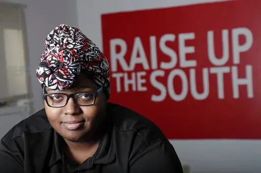 Food service worker Sheree Allen poses in the Raise Up offices, a branch of the Fight for $15 union, Thursday, Feb. 10, 2022, in Durham, N.C. After decades of decline, U.S. unions have a new reason for hope: younger workers. Sheree Allen was hoping for benefits when she joined the food service company Chartwells last August. Chartwells says it offers health care, paid time off and a 401 (k) plan to its workers, but Allen says she has never been given information about those benefits despite aski