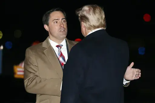 President Donald Trump greets Ohio Secretary of State Frank LaRose, Jan. 9, 2020, as he arrives at Toledo Express Airport, in Swanton, Ohio. The Republican secretaries of state in Ohio, West Virginia and Missouri all have promoted their states’ elections as fair and secure. Yet each also is navigating a fine line on how to address election fraud conspiracies, as they eye campaigns for U.S. Senate or governor in 2024. (AP Photo/ Jacquelyn Martin, File)