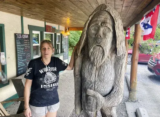 Pauline Bauer leans against a wooden statue outside Bob's Trading Post, her restaurant in Hamilton, Pa., July 21, 2021. Bauer, who screamed death threats directed at then-House Speaker Nancy Pelosi while storming the U.S. Capitol on Jan. 6, 2021, was sentenced on Tuesday to two years and three months in prison. (AP Photo/Michael Kunzelman)