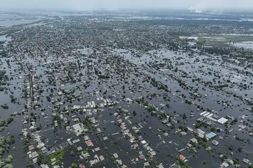 Houses are seen underwater in the flooded town of Oleshky, Ukraine, June 10, 2023. An AP investigation has found that Russian occupation authorities vastly and deliberately undercounted the dead in one of the most devastating chapters of the 22-month war in Ukraine - the flooding that followed the catastrophic explosion that destroyed the Kakhovka Dam in the southern Kherson region. (AP Photo/Evgeniy Maloletka, File)