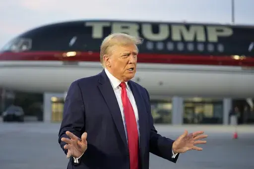 Former President Donald Trump speaks with reporters before departure from Hartsfield-Jackson Atlanta International Airport, Aug. 24, 2023, in Atlanta. A liberal group has filed a lawsuit to bar Trump from the primary ballot in Colorado. The lawsuit contends Trump is ineligible to run for the White House again under a rarely used clause in the U.S. Constitution aimed at candidates who have supported an “insurrection.” (AP Photo/Alex Brandon, File)