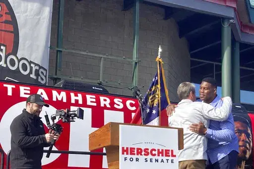 Georgia Gov. Brian Kemp campaigns alongside Senate candidate Herschel Walker on Saturday, Nov. 19, 2022 in Smyrna, Ga.   (AP Photo/Bill Barrow)