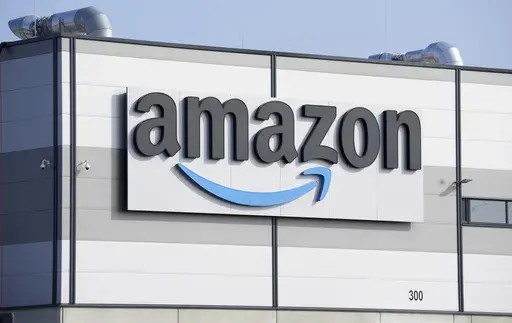 An Amazon company logo marks the facade of a building in Schoenefeld near Berlin, March 18, 2022. The Federal Trade Commission and 17 state attorney generals filed an antitrust lawsuit against Amazon on Tuesday, Sept. 26, 2023, alleging the e-commerce behemoth uses its position in the marketplace to inflate prices on other platforms, overcharge sellers and stifle competition. (AP Photo/Michael Sohn, File)