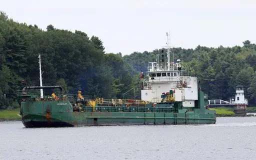 Spectators watch as a dredger works to deepen a shallow channel in the Kennebec River, upstream from the Doubling Point Lighthouse, Aug. 5, 2011, in Arrowsic, Maine. Eleven people were hurt when a walkway collapsed during an annual event that encourages tours of Maine lighthouses. The wooden walkway collapsed at Doubling Point Lighthouse on Saturday, Sept. 9, 2023. (AP Photo/Robert F. Bukaty, file)