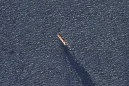 In this satellite image provided by Planet Labs, the Belize-flagged bulk carrier Rubymar is seen in the southern Red Sea near the Bay el-Mandeb Strait leaking oil after an attack by Yemen's Houthi rebels Tuesday, Feb. 20, 2024. Despite a month of U.S.-led airstrikes, Yemen's Iran-backed Houthi rebels remain capable of launching significant attacks. This week, they seriously damaged a ship in a crucial strait and apparently downed an American drone worth tens of millions of dollars. (Planet Labs 