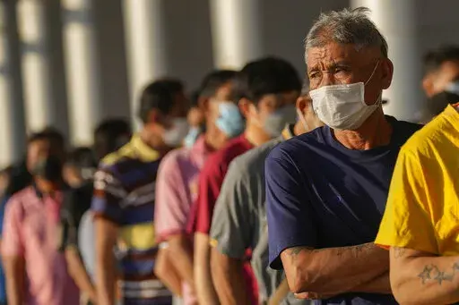 Local residents wait in long lines to receive shots of the Pfizer vaccine at the Central Vaccination Center in Bangkok, Thailand, Monday, Jan. 10, 2022. Thai health authorities approved new guidelines Friday, Jan. 28, 2022, outlining the parameters for declaring the coronavirus pandemic an endemic disease. (AP Photo/Sakchai Lalit, File)