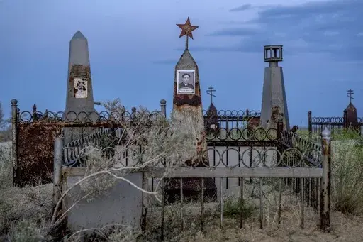 Graves are visible near the dried-up Aral Sea outside Aralsk, Kazakhstan, Monday, July 3, 2023. (AP Photo/Ebrahim Noroozi)