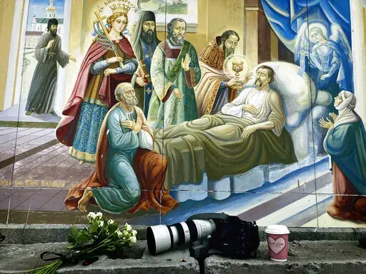 Flowers, Sony cameras, and a cup of coffee sit outside the memorial service of a Ukrainian soldier killed during a battle with Russian soldiers in Kyiv, Ukraine, in this Saturday, June 18, 2022 photo taken with an iPhone. "Sometimes I use the phone camera when I want to send an image immediately by message or Whatsapp — a way to communicate something to someone through an image and no words," wrote Pisarenko. (AP Photo/Natacha Pisarenko)