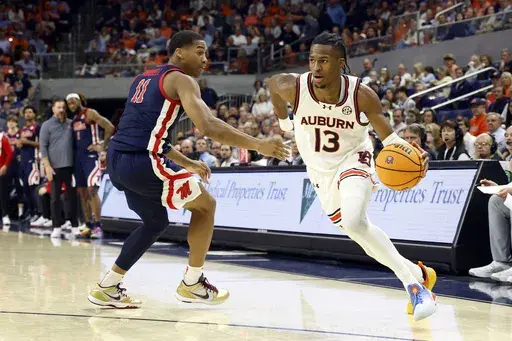 Auburn guard Miles Kelly (13) drives the baseline around Mississippi guard Matthew Murrell (11) during the second half of an NCAA college basketball game, Wednesday, Feb. 26, 2025, in Auburn, Ala. (AP Photo/Butch Dill)