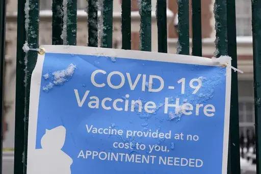 A sign covered with ice advertises a COVID-19 vaccination site in New York, Tuesday, Feb. 2, 2021. On Friday, Nov. 17, 2023, The Associated Press reported on stories circulating online incorrectly claiming over-the-counter cold and cough medications are being pulled from drugstore shelves in an effort to start the “next plandemic” or force people to get the COVID-19 vaccine. (AP Photo/Seth Wenig, File)