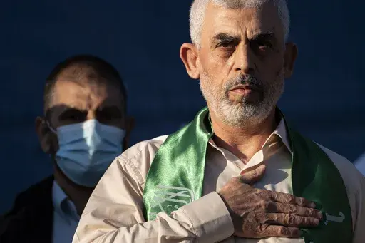 Yahya Sinwar, Palestinian leader of Hamas in the Gaza Strip, places his hand over his heart on stage after greeting supporters at a rally on May 24, 2021, in Gaza City, the Gaza Strip. (AP Photo/John Minchillo, File)