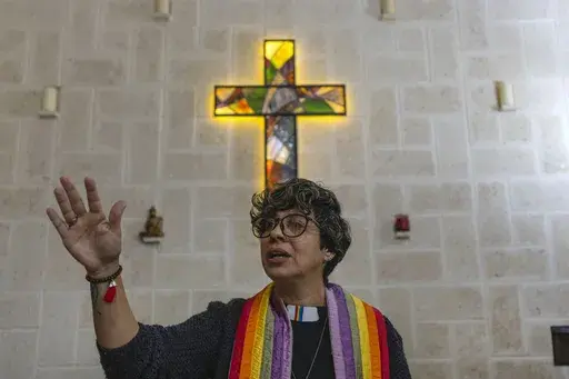 Rev. Elaine Saralegui, wearing a rainbow-colored clergy stole and her clerical collar, leads a service at the Metropolitan Community Church, an LGBTQ+ inclusive house of worship, in Matanzas, Cuba, Friday, Feb. 2, 2024. In recent years, the communist-run island barred anti-gay discrimination, and a 2022 government-backed “family law” — approved by popular vote — allowed same-sex couples the right to marry and adopt. (AP Photo/Ramon Espinosa) (AP Photo/Ramon Espinosa)