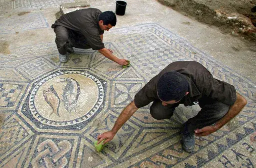 Prisoners work at a nearly 1,800-year-old decorated floor from an early Christian prayer hall discovered by Israeli archaeologists on Sunday, November 6, 2005 in the Megiddo prison. Israeli officials are considering uprooting the mosaic and loaning it to the controversial Museum of the Bible in Washington D.C., a proposal that has upset archaeologists and underscores the hardline government's close ties with evangelical Christians in the U.S. (AP Photo/Ariel Schalit, File)