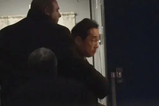 In this image made from video provided by Japan's NTV, Japanese Prime Minister Fumio Kishida gets on train in Przemysl, Poland, early Tuesday, March 21, 2023, heading to Kyiv for talks with Ukrainian President Volodymyr Zelenskyy. Kishida’s surprise trip to Ukraine comes just hours after he met with Indian Prime Minister Narendra Modi in New Delhi. (NTV via AP)