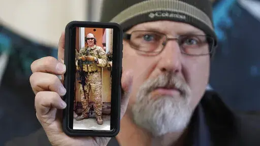 Matthew Butler, who spent 27 years in the Army, holds a 2014 photograph of himself during his last deployment in Kabul Afghanistan, on Wednesday, March 30, 2022, in Sandy, Utah. Butler is now one of the military veterans in several U.S. states who are helping convince conservative lawmakers to take cautious steps toward allowing the therapeutic use of hallucinogenic mushrooms and other psychedelic drugs. The therapeutic used of so-called magic mushrooms and other psychedelic drugs is making inro