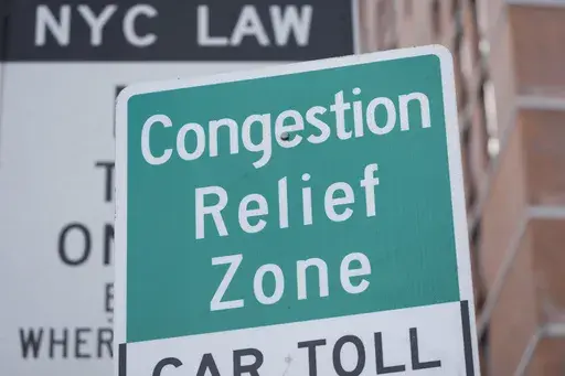 Signs, including some advising drivers of congestion pricing tolls, are displayed near the exit of the Lincoln Tunnel in New York, Wednesday, Feb. 19, 2025. (AP Photo/Seth Wenig)