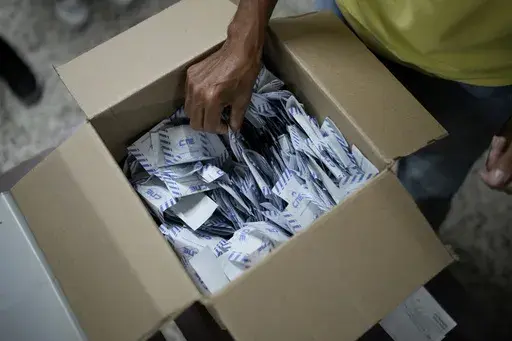 Electoral officials tally votes after polls closed for presidential elections in Caracas, Venezuela, Sunday, July 28, 2024. (AP Photo/Matias Delacroix)