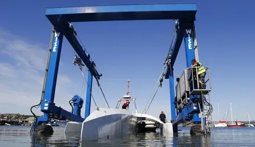 Technicians lower the Mayflower Autonomous Ship into the water at its launch site on Sept. 14, 2020, for its first outing on water since being built in Turnchapel, Plymouth south west England. The sleek autonomous trimaran docked in Halifax, Nova Scotia on Sunday, June 5, 2022, after more than five weeks crossing the Atlantic Ocean from England, according to tech company IBM, which helped build it. (AP Photo/Alastair Grant, File)
