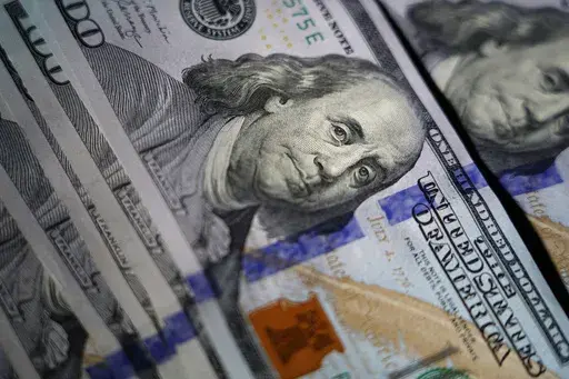 The likeness of Benjamin Franklin is seen on U.S. $100 bills, Thursday, July 14, 2022, in Marple Township, Pa. In preparation for 2024, you can shore up your finances by creating some financial New Year’s resolutions for yourself. (AP Photo/Matt Slocum, File)