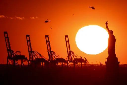 Container cranes at a port in New Jersey appear behind the Statue of Liberty, Sunday, Nov. 20, 2022, in New York. The global economy will come "perilously close" to a recession this year, led by weaker growth in all the world's top economies — the United States, Europe and China — the World Bank warned Tuesday.(AP Photo/Julia Nikhinson, File)