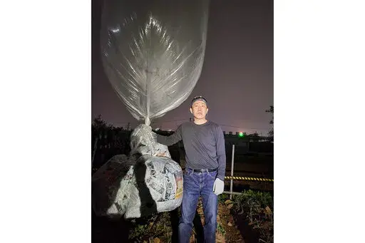 Park Sang-hak, a North Korean defector-turned-activist, prepares to release a balloon bearing leaflets at the border town of Gimpo, South Korea, on April 25, 2022. The South Korean activist said Thursday, April 28, he launched a million propaganda leaflets by balloon into North Korea this week, in his first such campaign while standing trial for past leafleting under a contentious new law that criminalizes such actions.(Courtesy of Fighters For A Free North Korea via AP)