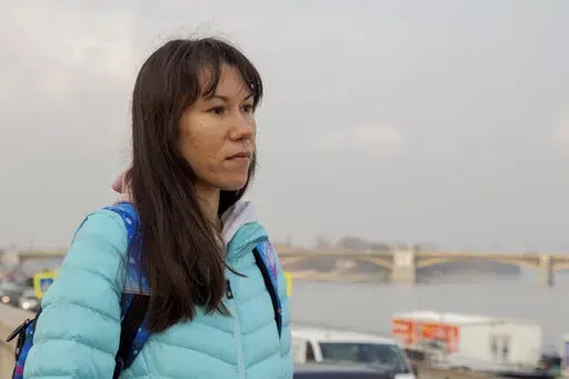Olena, a Russian citizen fleeing from Kyiv, Ukraine (no family name given for safety reason) stands near the River Danube in downtown Budapest on Friday, March 4, 2022. Olena who years ago left her home country in opposition to Vladimir Putin's government has been forced to flee again — this time from her adopted home of Kyiv — as Putin's armed forces assault Ukraine. (AP Photo/Balazs Kaufmann)