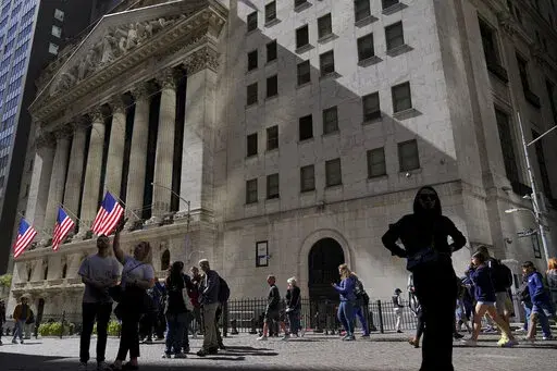 Visitors to the financial district walk past the New York Stock Exchange, Friday, Sept. 23, 2022, in New York. After sweeping through battles in statehouses across the country, the war against what's called ESG investing is heating up in Congress. (AP Photo/Mary Altaffer, File)