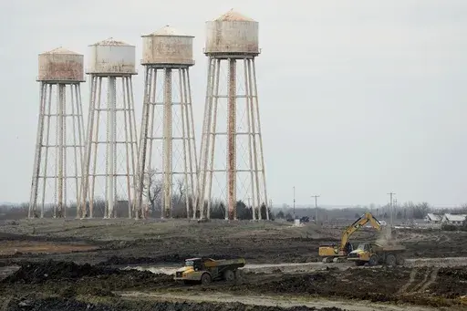 Workers prepare the site of a $4 billion Panasonic EV battery plant Thursday, March 30, 2023, near DeSoto, Kan. Economic incentives offered by Kansas state and local governments beat out those offered by neighboring Oklahoma to help lure the project to the site on land formerly occupied by an Army ammunition plant. (AP Photo/Charlie Riedel)