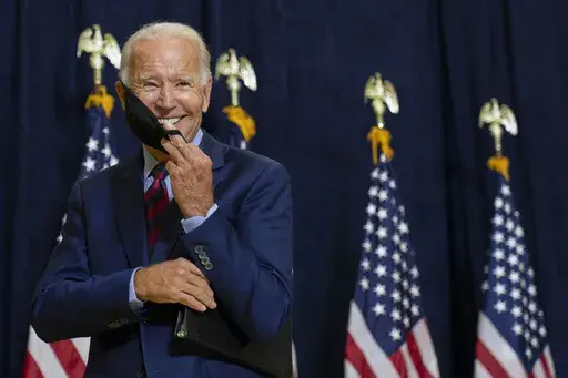 Democratic presidential candidate former Vice President Joe Biden smiles as he puts on his face mask after speaking to media in Wilmington, Del., on Sept. 4, 2020. (AP Photo/Carolyn Kaster, File)