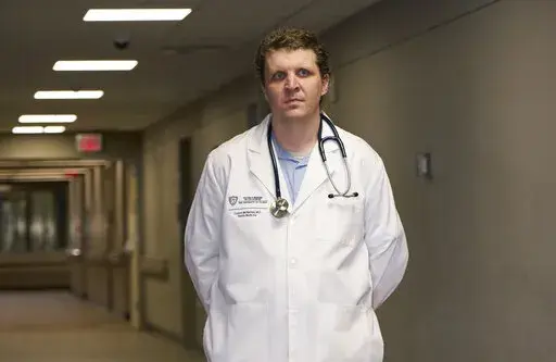 Dr. Connor McNamee, a third-year family medicine resident at the University of Toledo Medical Center, poses at the medical center, Tuesday, Oct. 18, 2022, in Toledo, Ohio. Students in obstetrics-gynecology and family medicine are facing tough choices about where to advance their training in a landscape where legal access to abortion varies from state to state. McNamee began exploring abortion training outside Ohio last summer. A state law bans most abortions after cardiac activity is detected, b