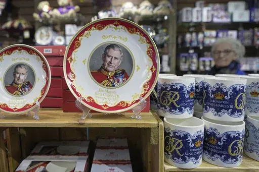 Coronation plates and cups are displayed for sale in a gift shop in London, Monday, April 24, 2023. The May 6 coronation is luring royal fans and far-flung visitors fascinated by the ceremonial spectacle — and drama — of the monarchy and eager to experience a piece of British history. Tour companies, shops and restaurants are rolling out the red carpet, whether it's a decked-out bus tour of London's top sights boasting high tea or merchandise running from regal to kitschy. (AP Photo/Kin Cheu