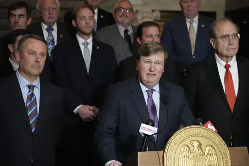 Mississippi Republican Gov. Tate Reeves, center, stands with House Speaker Jason White, R-West, left, and Republican Lt. Gov. Delbert Hosemann, right, as well as the legislators behind him, as he praises the passing of a state incentives package for a Mississippi factory that will manufacture batteries for electric vehicles — a project that promises 2,000 jobs, following a special session of the Mississippi Legislature, Thursday, Jan. 18, 2024, at the Mississippi Capitol in Jackson, Miss. (AP 